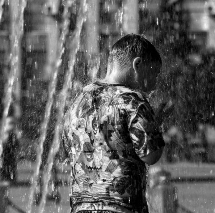 Estate 2026 in Veneto, un ragazzo si rinfresca a una fontana