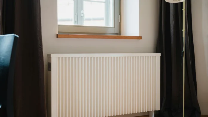 Termosifone bianco sotto una finestra, immagine illustrativa delle spese per il riscaldamento