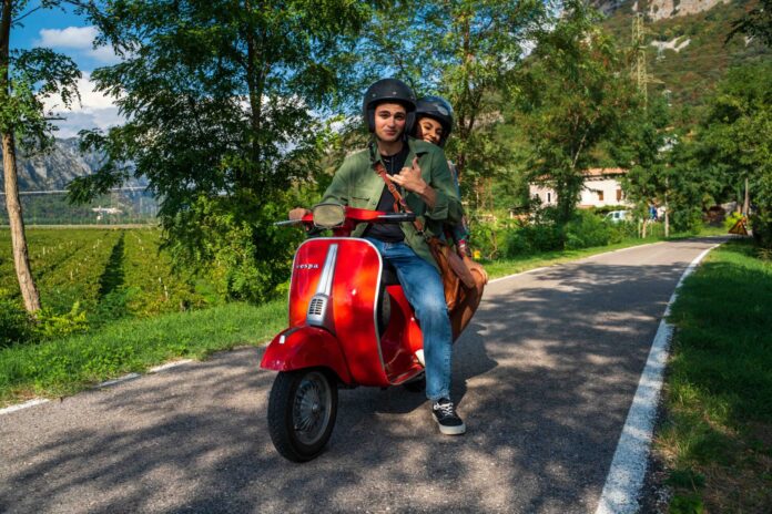 Alonso e Nina su una Vespa rossa in una scena della produzione della Fucina Machiavelli