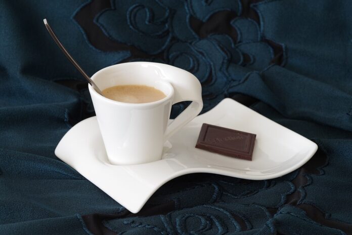 Tazzina di caffè espresso con piattino e cioccolato, immagine di repertorio sulla cultura dei bar
