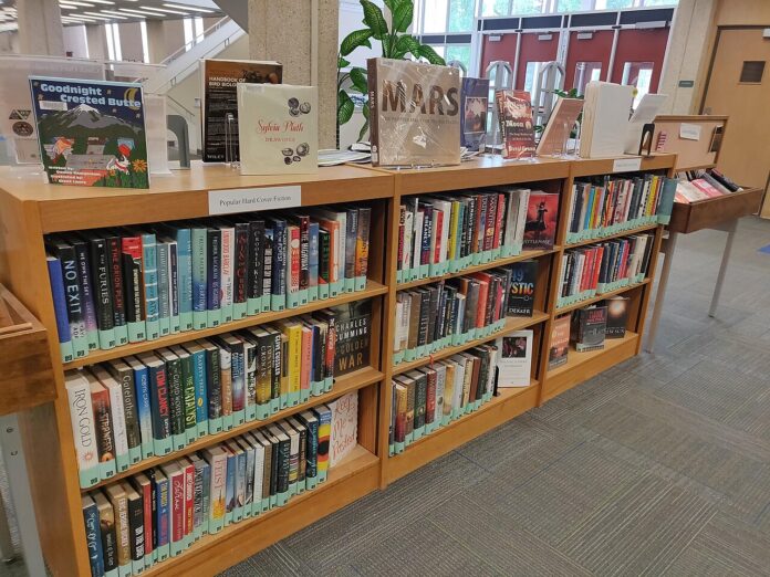 Scaffale con libri ed espositori in una biblioteca, fotografia di repertorio