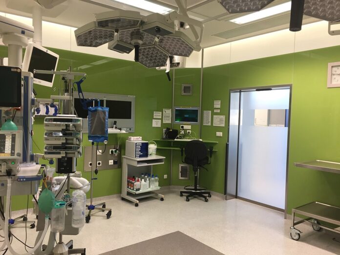 Sala operatoria con lettino, lampade e monitor, immagine di repertorio