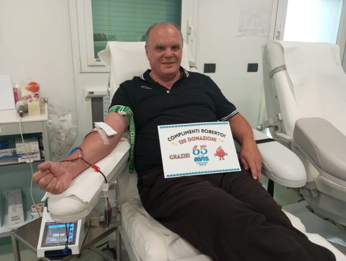 Roberto Gaole durante la donazione, con il cartello di AVIS Soave per le sue 120 donazioni