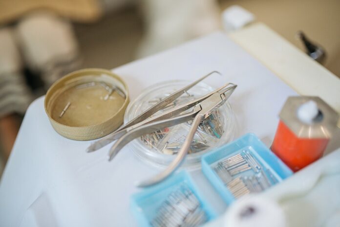 Pinzette e strumenti odontoiatrici disposti sul piano di uno studio dentistico
