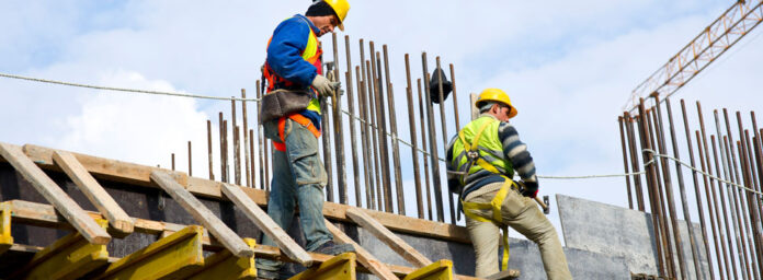 Lavoratori con casco e imbracatura in un cantiere, immagine di repertorio sulla sicurezza sul lavoro
