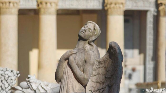 Cimiteri a Verona: statua di un angelo davanti al colonnato